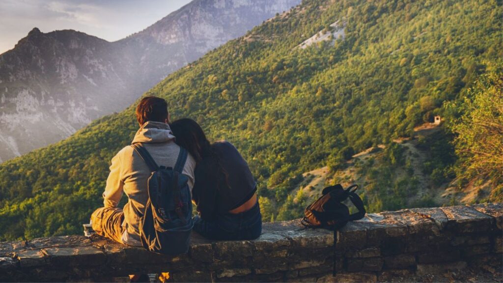 Couples Sitting in While Facing Mountain