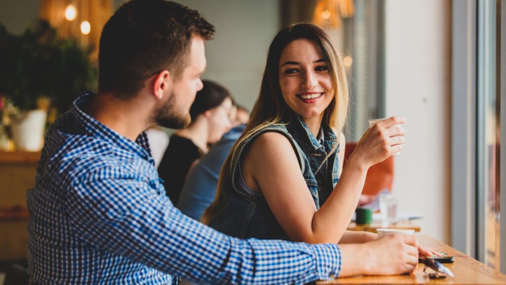 Couple in a Cafe Talking and Drinking Coffee